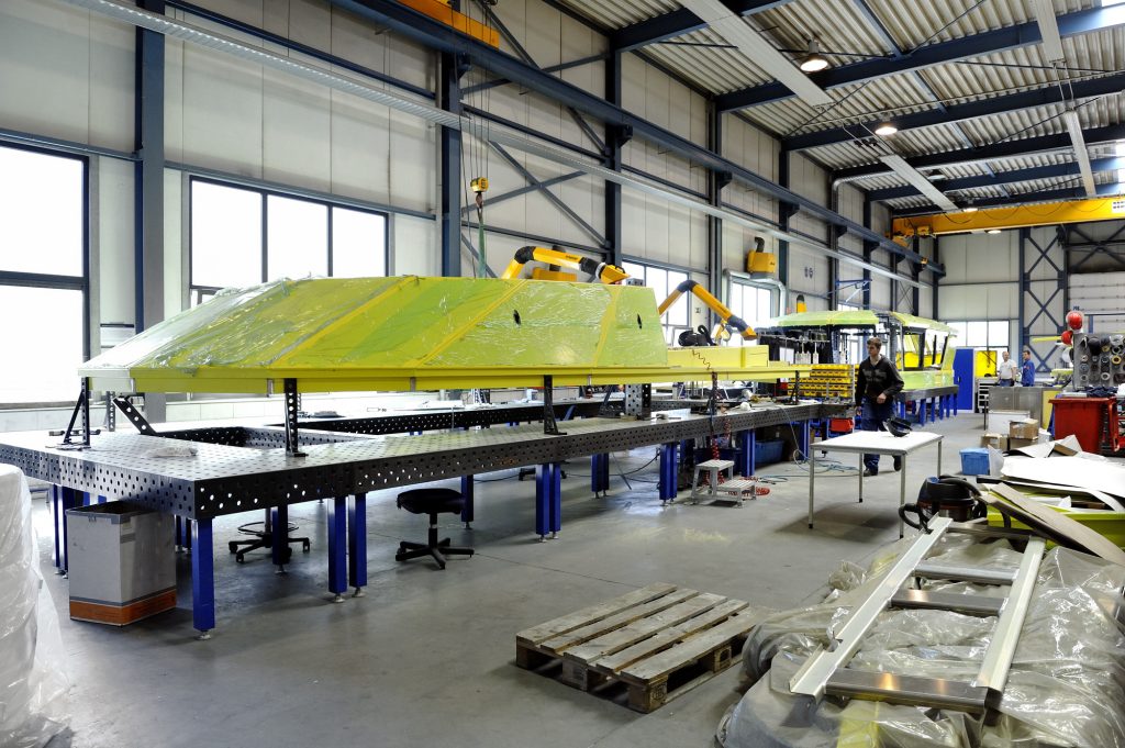 Multiple welding fume extraction arms in an industrial workshop