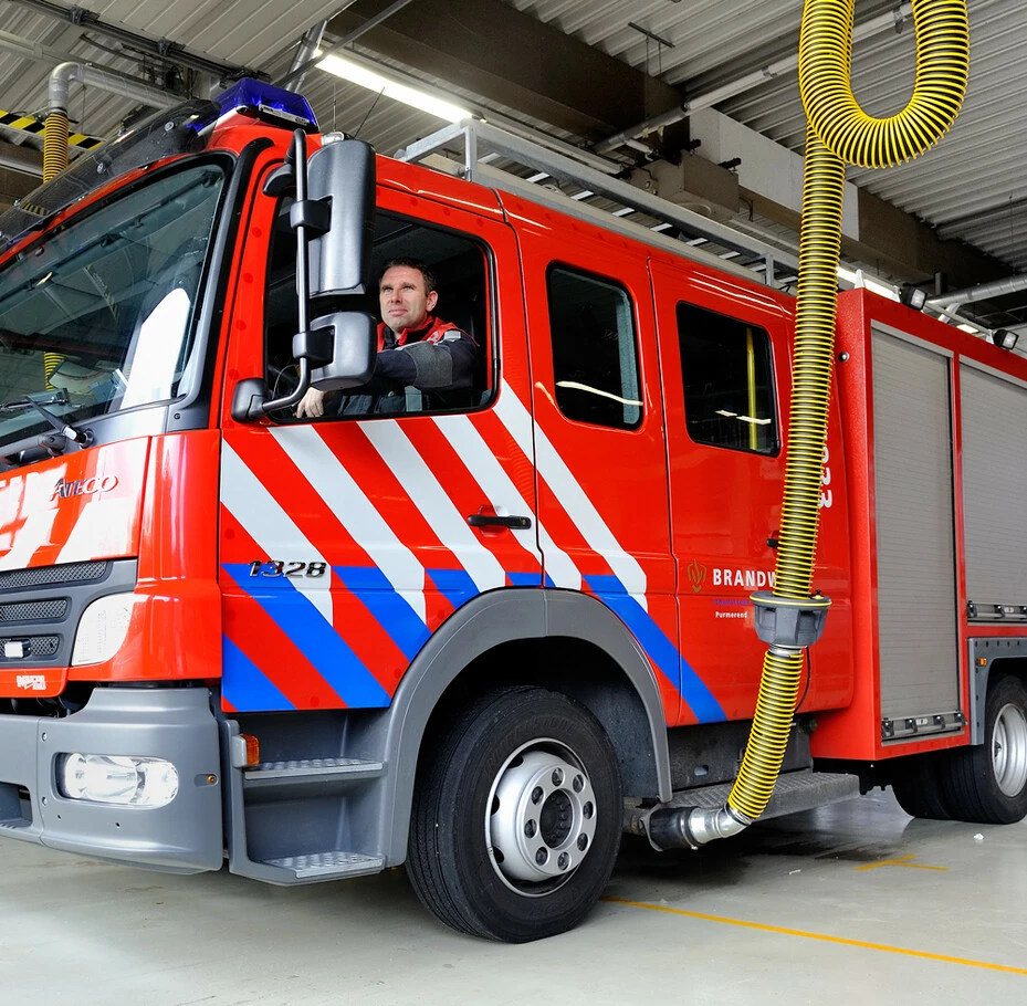 Plymovent exhaust extraction hose connected to a red fire truck tailpipe